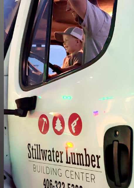 Stillwater Lumber building center van with a person and child inside